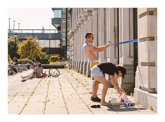 A person and a dog on a sunny pavement