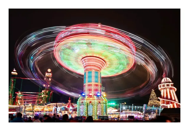 A brightly lit fairground ride at night